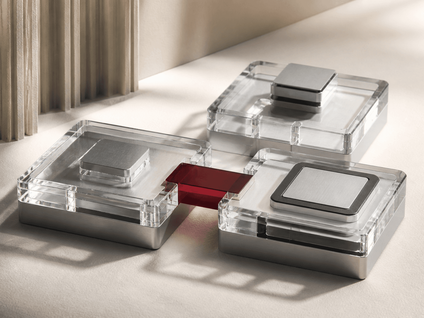 Connected clear-glass and brushed-metal modules joined by a carmine insert.