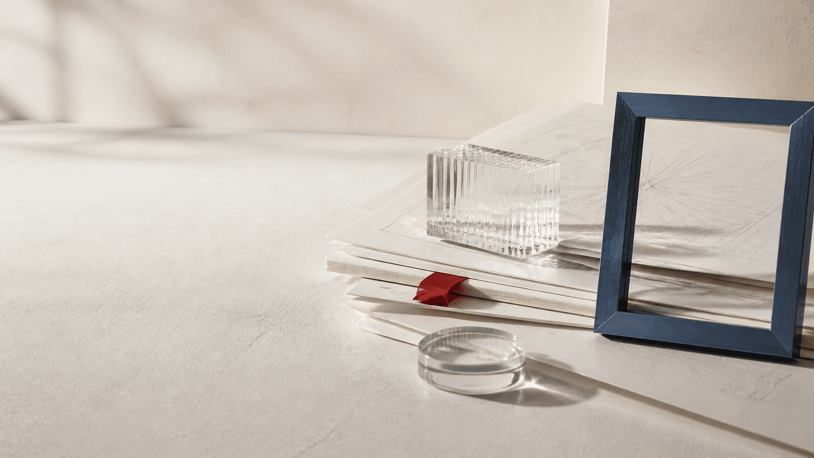 Ivory research papers, ribbed glass, blue graphite metal and a folded carmine index tab.