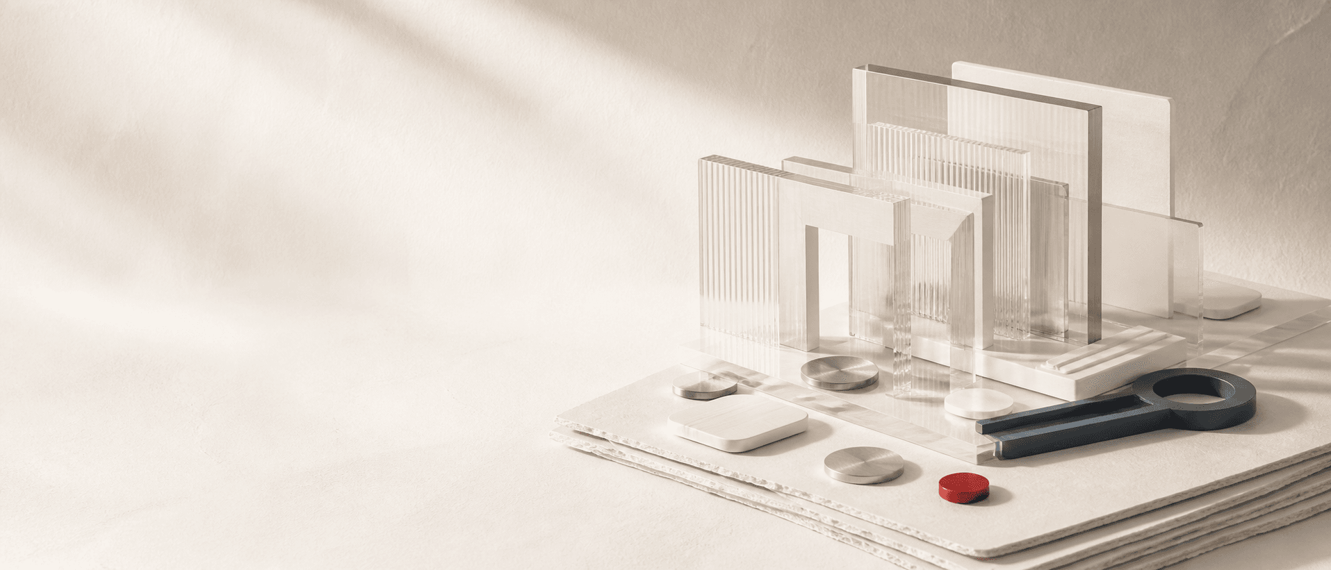 Layered clear gates, a graphite key, and a red token on folded paper